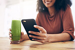 Green smoothie, smartphone and woman detox, healthy breakfast or diet inspiration on internet, blog or social media. Young person hand holding phone and juice, vegan or fruit drink for nutrition