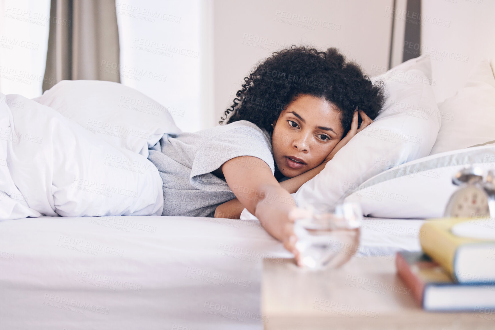 Buy stock photo Health, black woman in bed and wake up with water, tired and fatigue with burnout, overworked and sleepy. African American female, girl and in bedroom with aqua, illness and wellness in the morning