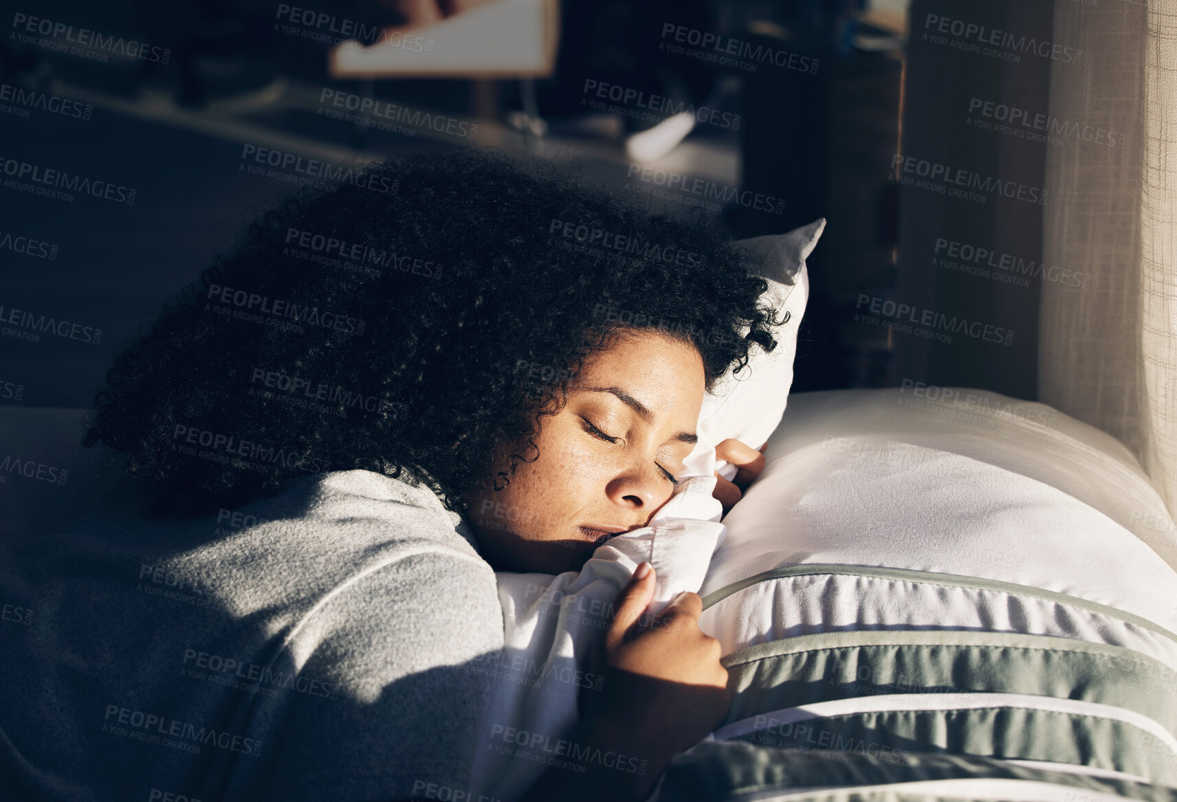 Buy stock photo Black woman, sleeping in bed for peace, quiet and rest or relax in home bedroom. Person with pillow to dream or for calm sleep with sunlight for health and wellness in apartment or hotel