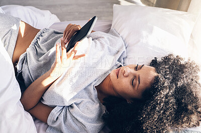 Buy stock photo Black woman, bed and phone in home bedroom for social media, texting or internet browsing in the morning. Technology, relax and female with mobile smartphone for web scrolling or networking in house.