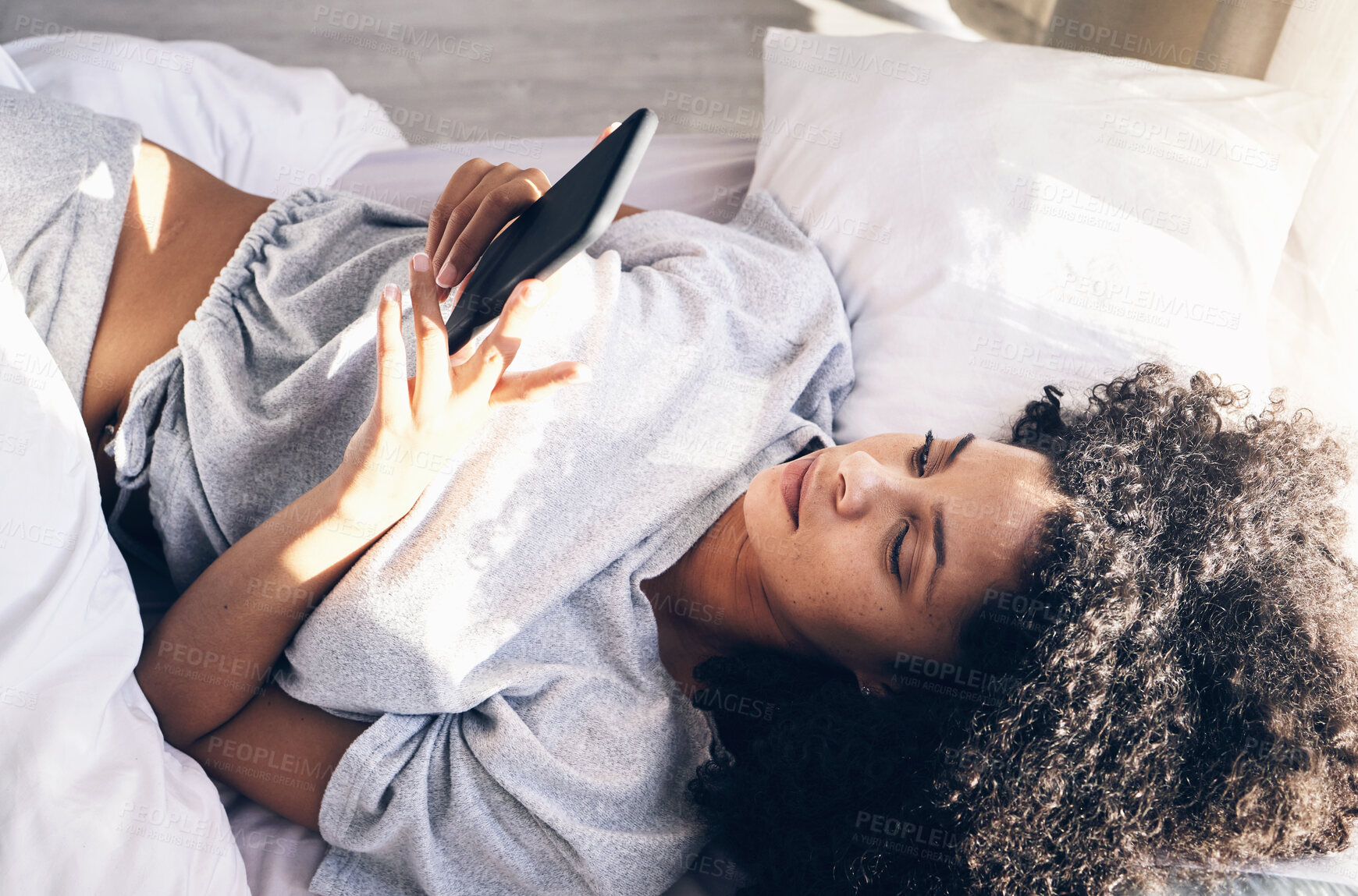 Buy stock photo Black woman, bed and phone in home bedroom for social media, texting or internet browsing in the morning. Technology, relax and female with mobile smartphone for web scrolling or networking in house.