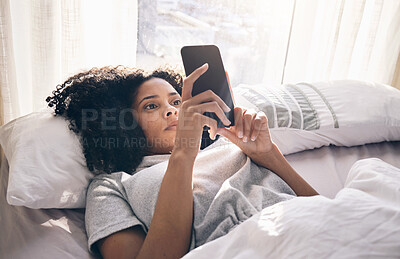 Buy stock photo Phone, black woman and typing in home bedroom for social media, texting or internet browsing in the morning. Technology, bed relax and female with mobile smartphone for web scrolling or networking.