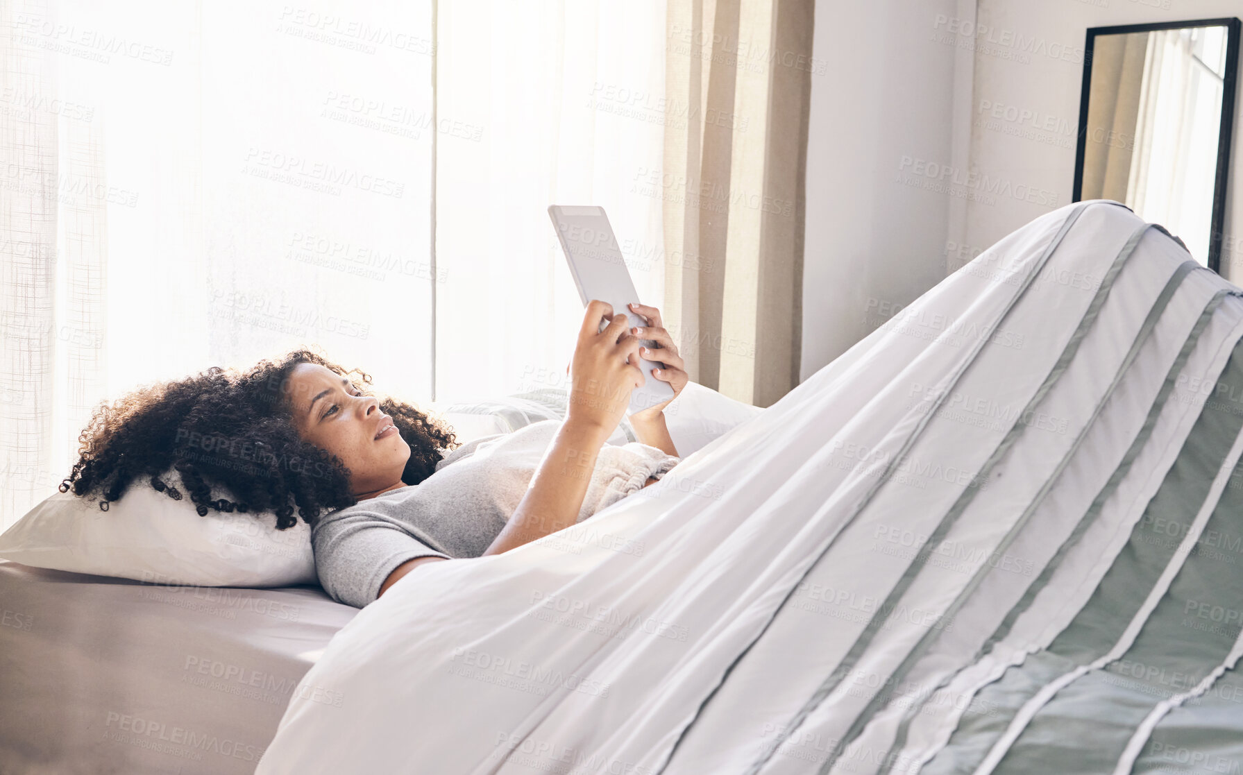 Buy stock photo Relax, black woman and tablet in bed in bedroom for social media, texting or internet browsing in the morning. Technology, home and female with digital touchscreen for web scrolling after waking up.