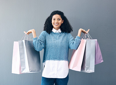 Buy stock photo Shopping, black woman and portrait of a happy customer with bags after boutique or shop sale. Isolated, gray background and female smile in a studio holding a bag with discount market product