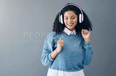 Buy stock photo Music, dance and black woman in studio with freedom, streaming or good mood on grey background. Radio, podcast and girl relax while dancing to audio, online and playlist on advertising isolated space