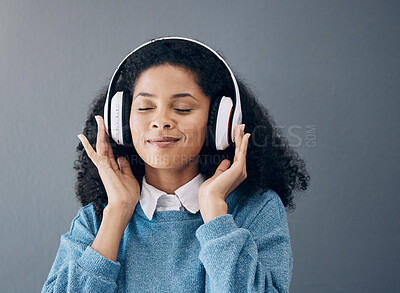 Buy stock photo Relax, music and black woman in studio with peace, streaming or good mood on grey background. Radio, podcast and girl with positive, mindset or audio, online or playlist on advertising isolated space