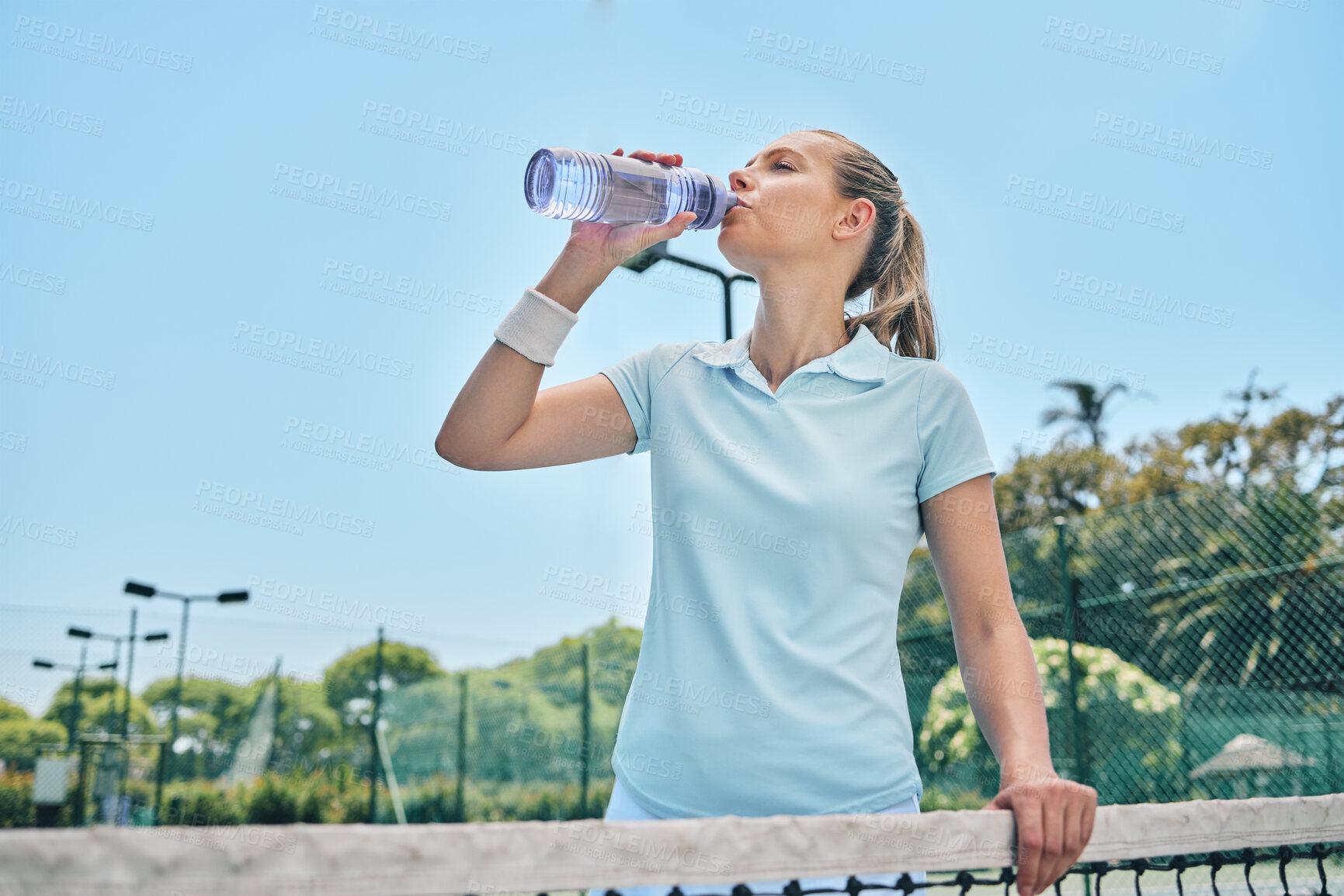 Buy stock photo Woman, tennis and drinking water for hydration after workout, exercise or intense training on court. Sporty female with bottle for refreshing drink, thirst or stay hydrated during sports exercising