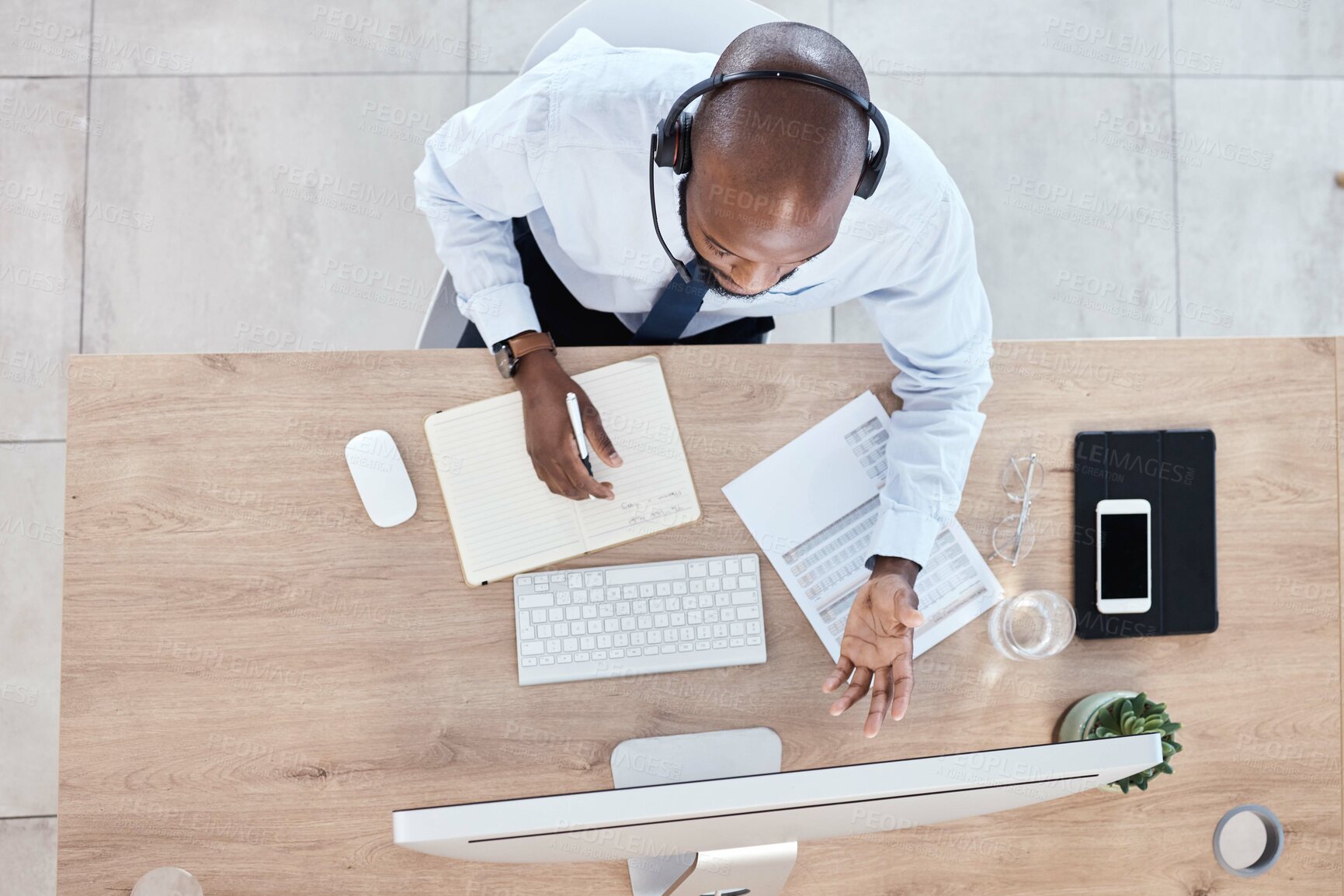 Buy stock photo Top view, black man or consultant in call center, customer service or talking with headset. African American male employee, agent or worker with computer, headphones or tech support to help in office