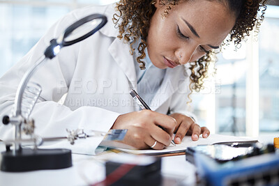 Buy stock photo Science, research and writing with a black woman doctor working in a laboratory for innovation or breakthrough. Notebook, data and checklist with a female scientist at work on a report in a lab