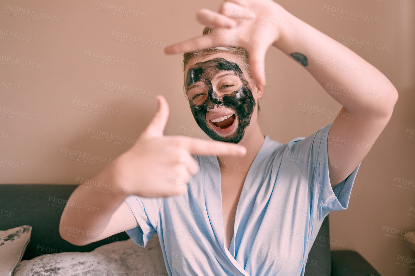 Buy stock photo Self care, face mask and funny woman in her home, house or apartment doing morning beauty routine and hand gesture. Portrait, relax and female taking picture frame or sign for skincare using charcoal