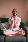 Self love, face mask and relax goofy woman in her home, house or apartment doing morning beauty routine with hand gesture. Portrait, relax and female  funny and excited for skincare using charcoal