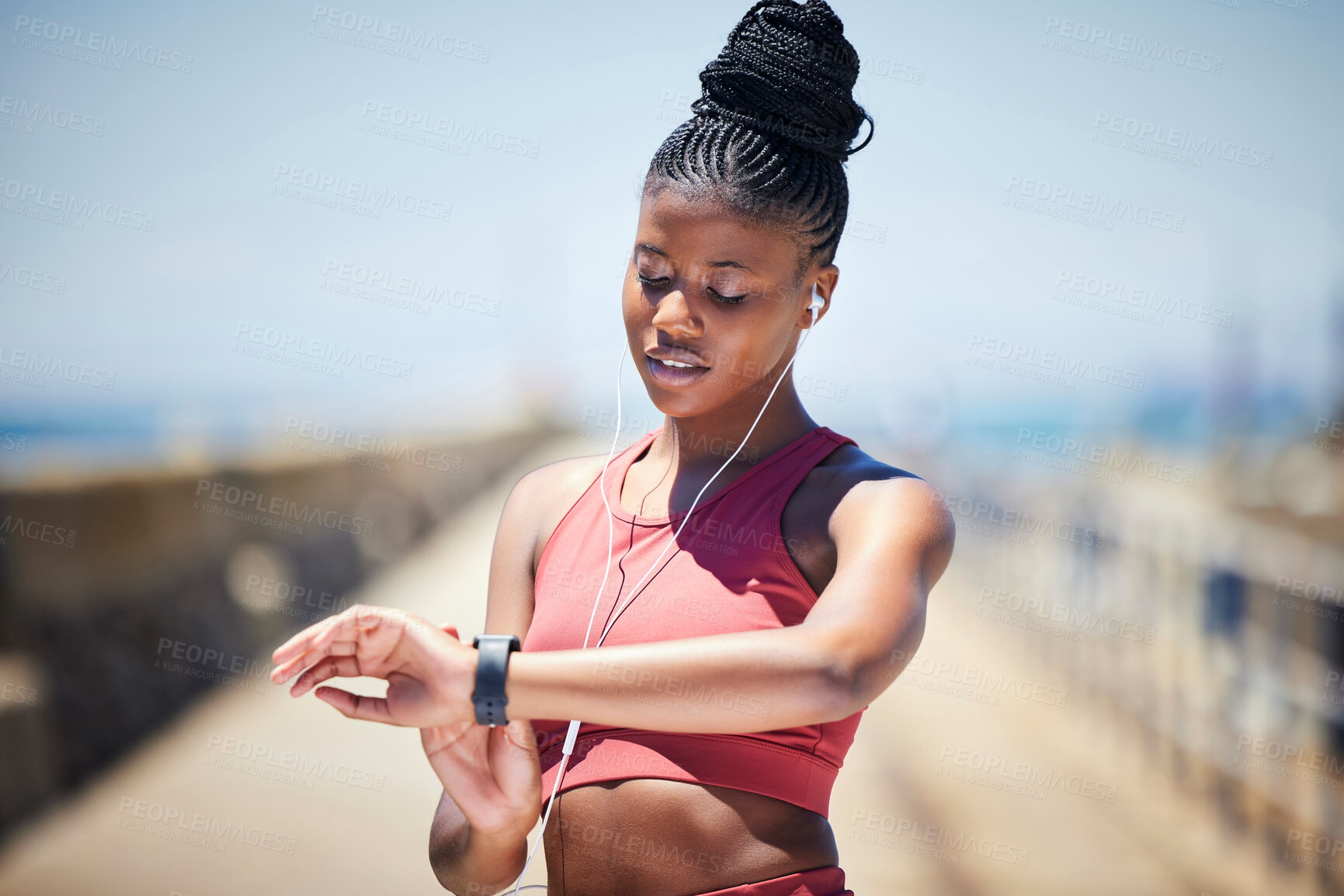 Buy stock photo Black woman, fitness and checking watch for time or monitoring performance after running exercise outside. African American female runner looking at wristwatch with earphones for tracking workout