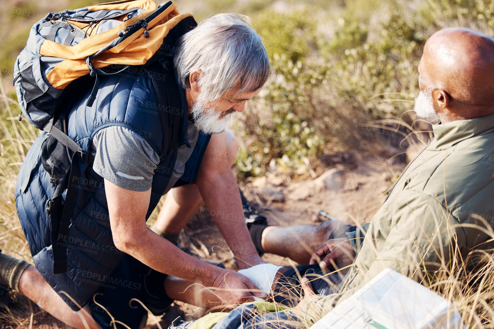 Buy stock photo First aid, leg injury and hiking with old men in nature for trekking, adventure and fitness. Help, bandage and medical with friends and knee pain on trail for backpacking, discovery and emergency