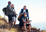 Senior, men and hiking in nature, relax and calm, sitting and happy on blue sky background. Elderly, friends and man hiker group bond on hill top, freedom and exercise, fitness or retirement activity