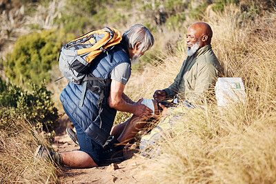 Buy stock photo First aid, injury and knee pain with old men in nature for trekking, adventure and fitness. Help, bandage and medical with friends and leg accident on trail for backpacking, discovery and emergency