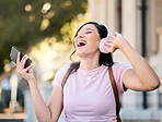 Music, headphones or dance by woman in city for travel, happy and freedom on building background. Radio, podcast and travelling girl student smile for app, online audio or subscription service 