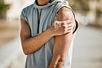 Arm, mockup and man in street with injury or ache in fitness, sports or cardio on blurred background. Shoulder pain, runner and hands of guy suffering heart attack sign, accident or risk in workout