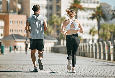 Buy stock photo Fitness, teamwork or coaching with a runner couple on the promenade for cardio or endurance from the back. Exercise, wellness or workout with a man and woman athlete running outdoor in the city