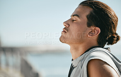 Buy stock photo Tired, fitness and breathing man for cardio training, workout or outdoor running break on blue sky mockup. Calm, thinking and athlete or sports person with exercise in summer by beach or ocean