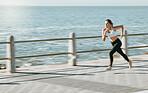 Woman, fitness and running by beach on mockup for exercise, workout or cardio routine. Active female runner in fast speed run, sprint or race by the ocean coast for healthy exercising in Cape Town