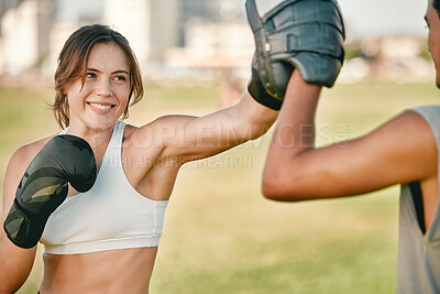 Boxing, woman and personal trainer exercise outdoor in nature park for fitness, health and wellness. Couple of friends happy about sports workout or mma training with motivation, energy and coaching