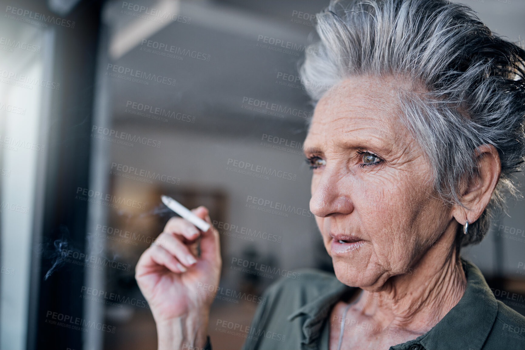 Buy stock photo Thinking, nicotine and a senior woman smoking a cigarette in her home while looking out from a window. Idea, smoke and cancer with a mature female tobacco smoker in a house for pension or retirement