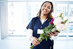 Pride, celebration and portrait of a doctor with flowers at a hospital for a promotion and gift for work. Medic, happy and female nurse with bouquet as present for promotion in healthcare nursing job