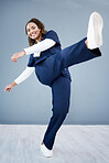 Kick, healthcare and black woman with celebration, achievement and grey studio background. Portrait, Jamaican female and medical professional with leg in air for happiness, promotion and employee