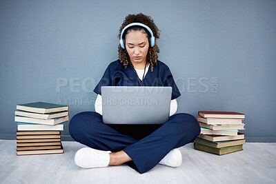 Buy stock photo Doctor, laptop or headphones of hospital music, podcast or radio in woman study research or mock up learning by wall. Thinking, technology or medical student listening to healthcare audio for books