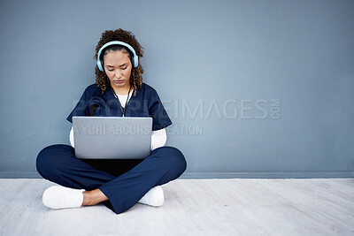 Buy stock photo Woman, laptop and headphones of hospital music, podcast or radio in woman study research or mockup nurse learning. Doctor, technology and medical student listening to healthcare audio for focus help