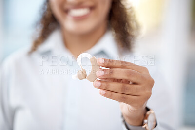 Buy stock photo Hand, hearing aid and disability with a black woman holding a listening device for dead people in a clinic. Medical, technology or insurance with a female medicine professional standing in a hospital