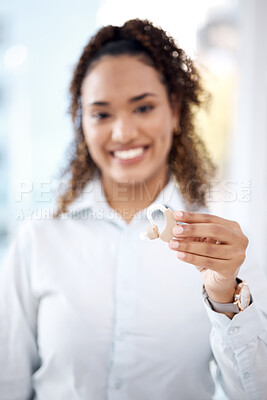 Buy stock photo Hand, hearing aid and audiology with a black woman holding a listening device for deaf people in a clinic. Medical, technology and insurance with a female medicine professional standing in a hospital