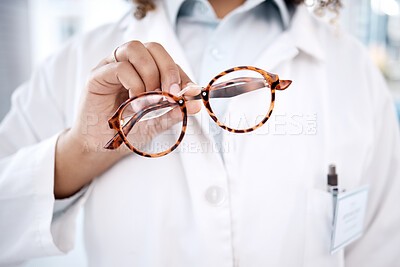Buy stock photo Glasses, hand and vision with a doctor woman holding a pair of frame eyewear in a clinic for sight correction. Healthcare, medical and insurance with a female optometrist showing prescription lenses