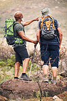 Nature, pointing and senior men hiking on mountain together for an outdoor backpack adventure. Freedom, fitness and elderly male friends bird watching and searching in the environment while trekking.