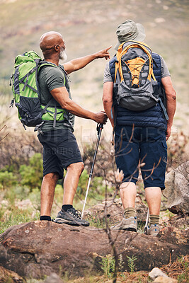 Buy stock photo Nature, pointing and senior men hiking on mountain together for an outdoor backpack adventure. Freedom, fitness and elderly male friends bird watching and searching in the environment while trekking.
