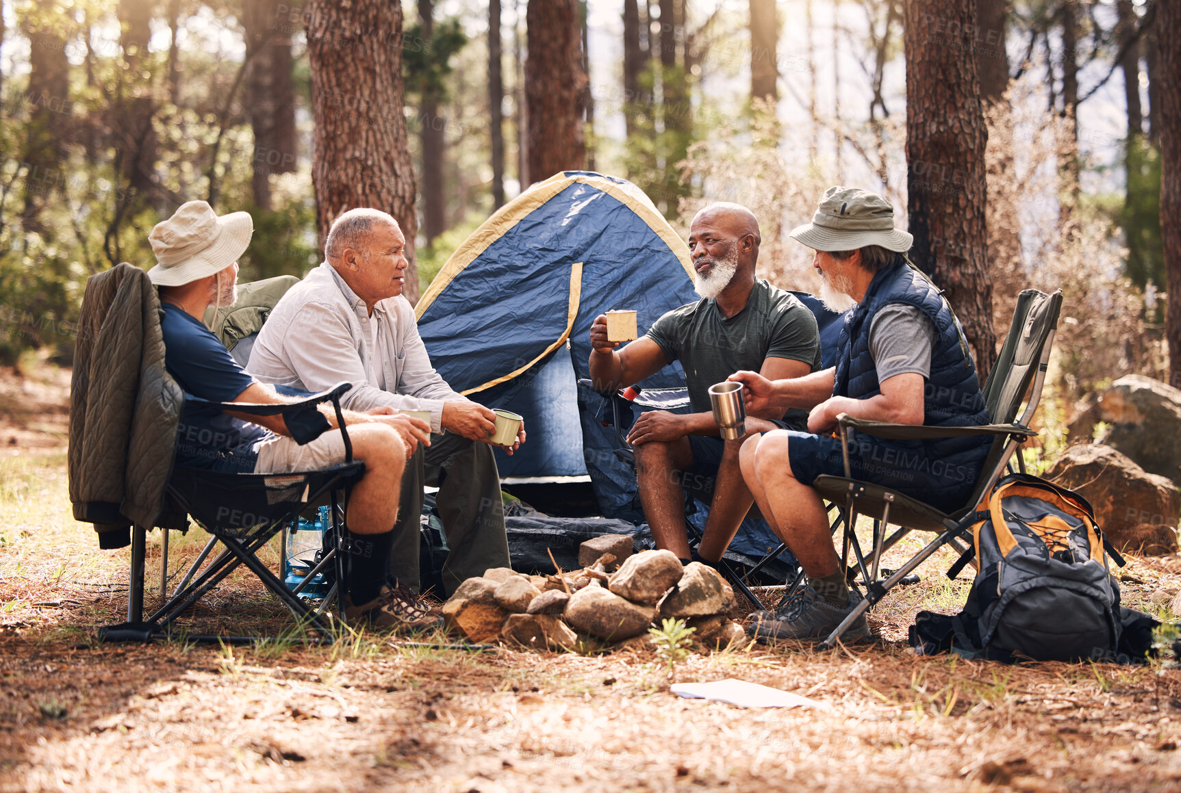 Buy stock photo Man, friends and camping in nature with coffee for travel, adventure or summer vacation together on chairs by tent in forest. Group of men relaxing, talking or enjoying natural camp by trees outdoors