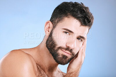 Buy stock photo Skincare, glow and portrait of a man feeling face isolated on a blue background in a studio. Beauty, clean and model touching facial beard, grooming and cleaning for dermatology treatment on backdrop