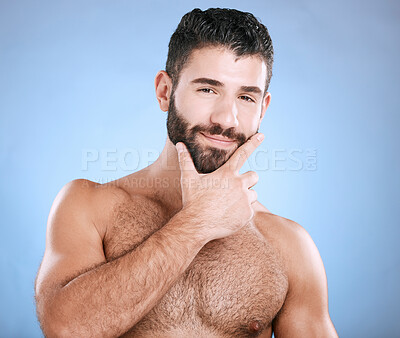 Buy stock photo Skincare, beauty and portrait of man with beard, hand on face and cleaning treatment isolated on blue background. Facial hygiene, happy male model and grooming health, smile and hair care in studio.