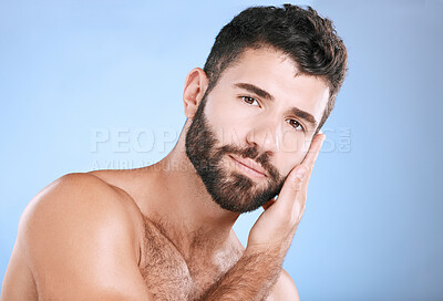 Buy stock photo Skincare, cosmetic and portrait of a man feeling face isolated on a blue background. Beauty, clean and model touching facial beard, grooming and cleaning for dermatology treatment on studio backdrop