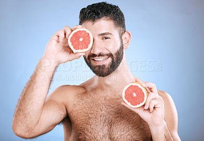 Buy stock photo Portrait, beauty and grapefruit with a man model in studio on a blue background for natural skincare or hygiene. Fruit, wellness and nutrition with a handsome male posing to promote a healthy diet
