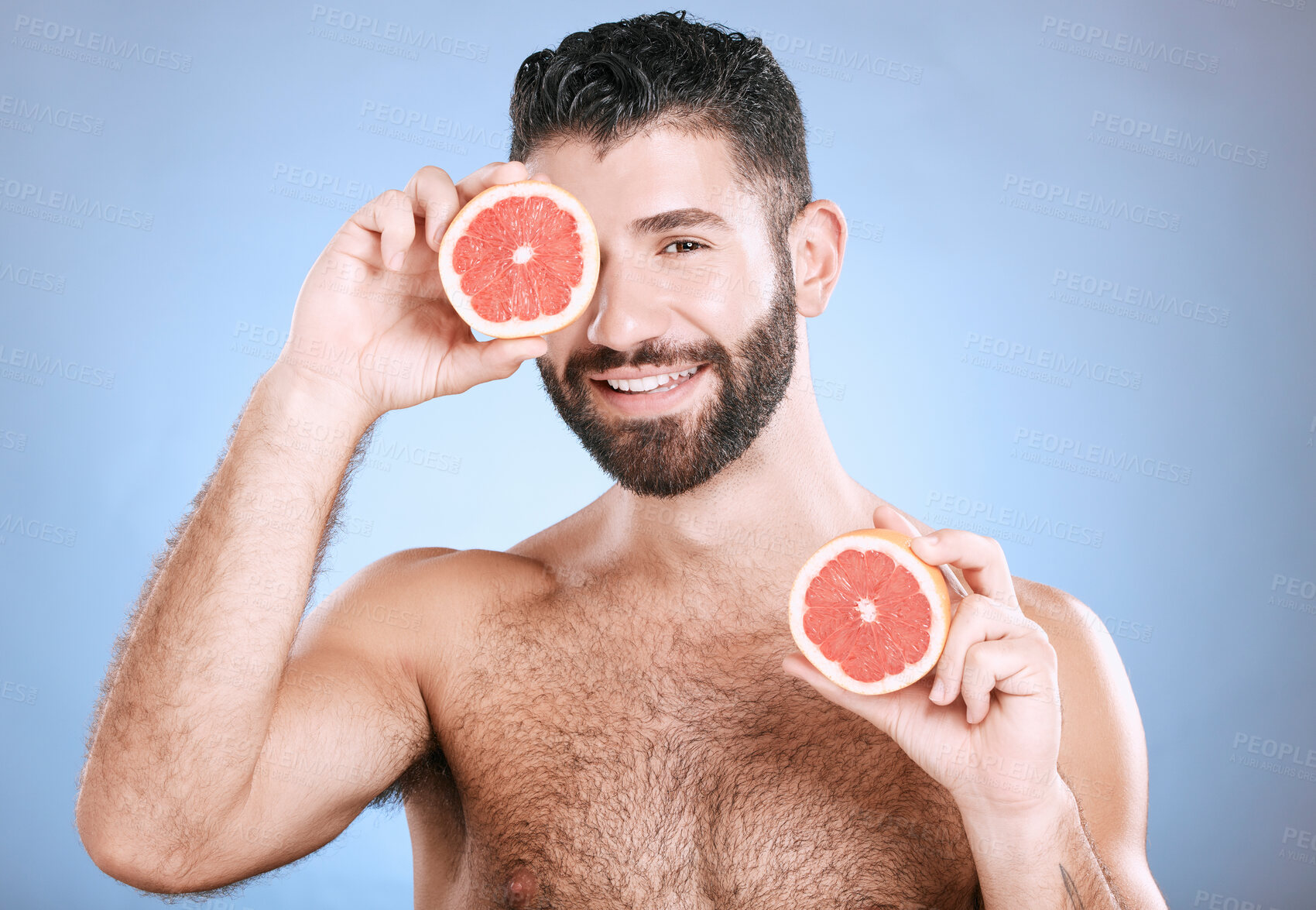 Buy stock photo Portrait, beauty and grapefruit with a man model in studio on a blue background for natural skincare or hygiene. Fruit, wellness and nutrition with a handsome male posing to promote a healthy diet