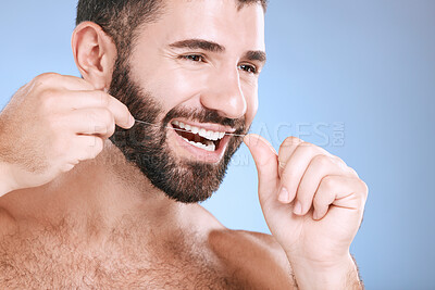 Buy stock photo Dental, product or floss with a man in studio on a blue background with teeth hygiene for healthy gums. Dentist, healthcare and mouth with a young male oral cleaning to remove plague or gingivitis
