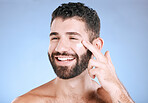 Face, cream and man laughing for beauty, sunscreen product and clean wellness on blue background. Happy male model, facial lotion and body cosmetics for natural skincare, studio aesthetics and smile