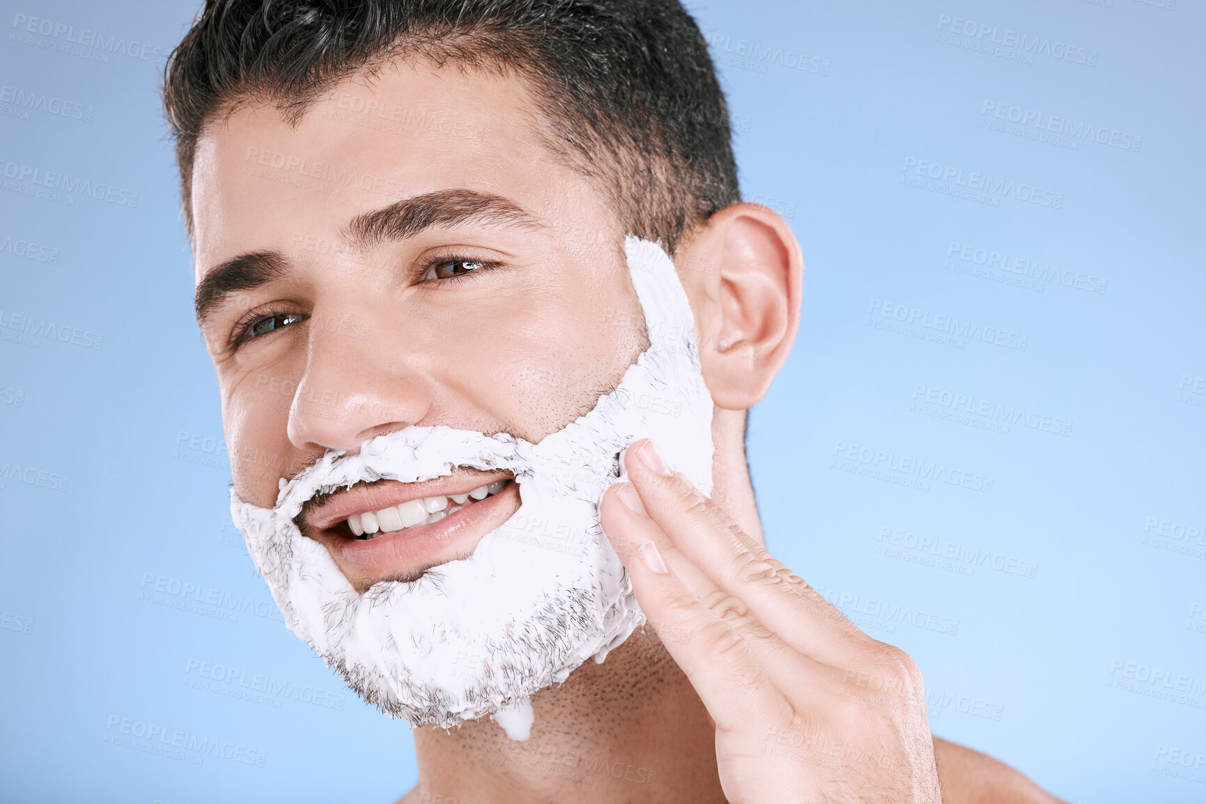 Buy stock photo Facial, foam on beard and man with smile and hand on face with product placement and mockup in studio. Shaving cream, hair and skincare for happy male model grooming, isolated on blue background.