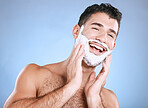 Facial, foam on beard and man with smile, hands on and product placement in studio mock up. Luxury shaving cream on face, hair and skincare for happy male model grooming, isolated on blue background.