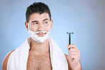 Facial, foam on beard and man with razor in hand, towel and product placement and mock in studio. Shaving cream on face, hair and skincare for happy male model grooming, isolated on blue background.