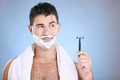 Buy stock photo Facial, foam on beard and man with razor in hand, towel and product placement and mock in studio. Shaving cream on face, hair and skincare for happy male model grooming, isolated on blue background.