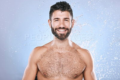 Buy stock photo Water splash, portrait and man in studio skincare, wellness and cleaning on blue background. Face, shower and happy male model relax in luxury, gentle and moisture for beauty, cosmetics or treatment