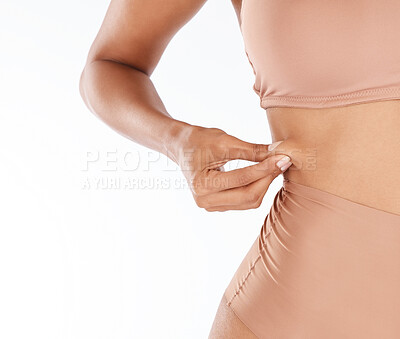 Buy stock photo Woman, pinch stomach and weight loss in studio for wellness, health and care for body by white background. Young model, girl and hands on abdomen skin for tummy tuck, liposuction and cosmetic surgery