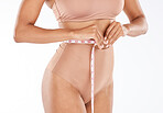 Tape, fitness body and woman isolated on a white background for lose weight or tummy tuck in underwear. Model person in lingerie, measure waist or stomach for liposuction results or health in studio